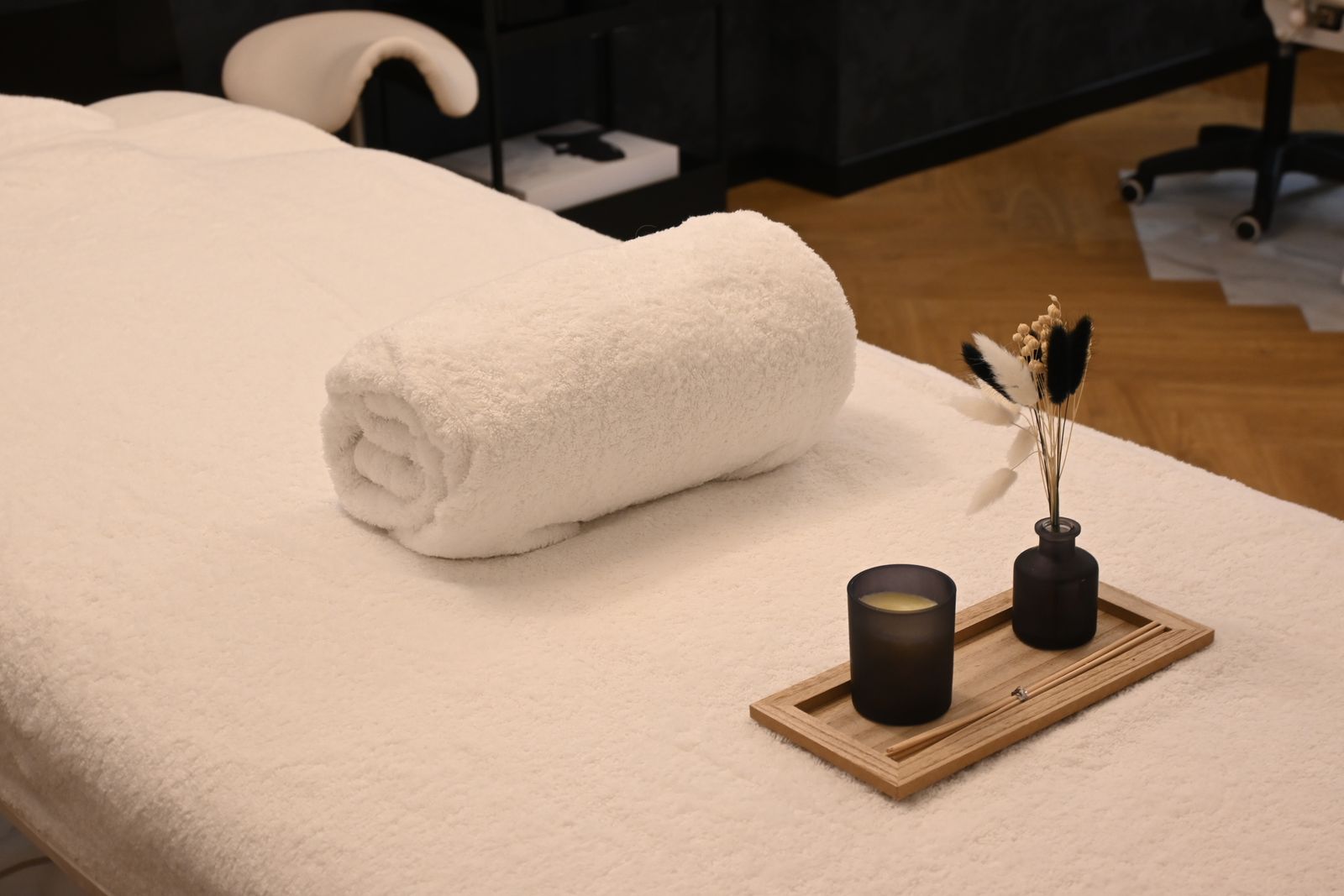 A quiet treatment room with a folded towel and candle